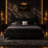 A black upholstered bed with a Batman-themed headboard, styled with dark gray and black bedding and decorative pillows in a minimalist gray bedroom.