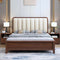 Wooden bed with beige upholstered headboard in a bedroom setting