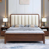 Wooden bed with beige upholstered headboard in a bedroom setting