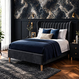A modern gray upholstered bed frame with a tufted headboard and wooden legs, styled in a bedroom with navy and white bedding, patterned wallpaper, and dark wood flooring.